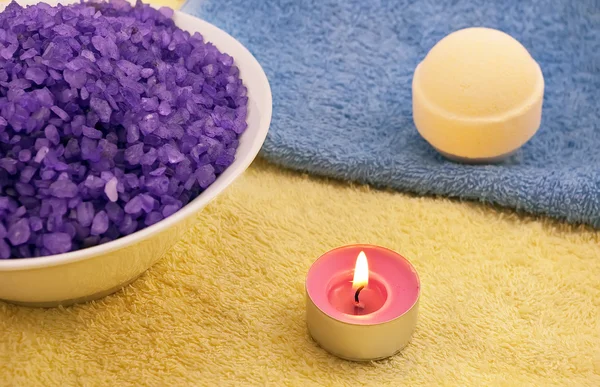 Фиолетовая соль со свечой и мячом для ванны — стоковое фото