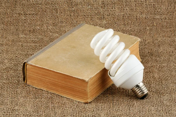 Energibesparing glödlampa och boken — Stockfoto