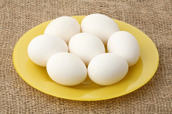 Ovos brancos em uma chapa — Fotografia de Stock