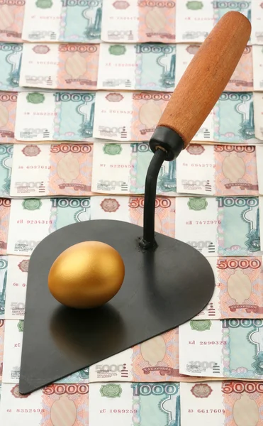 Gold egg and building trowel — Stock Photo, Image