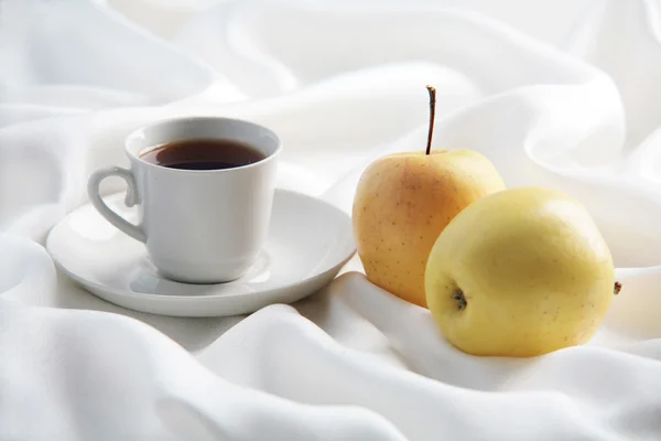 Zwarte koffie met gele appels op wit Rechtenvrije Stockfoto's