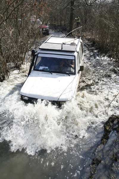 Белый автомобиль едет по реке Лицензионные Стоковые Изображения