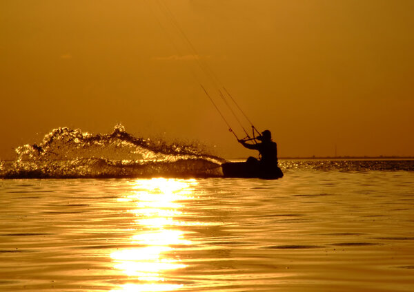 Silhouette of a kitesurf on a gulf on a