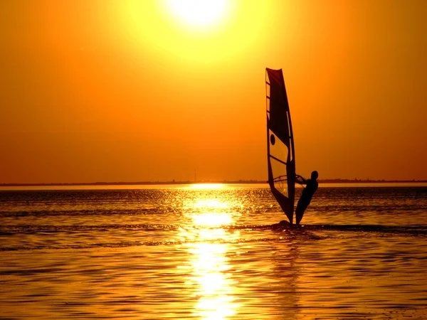 Silhueta de um windsurfista em ondas de um — Fotografia de Stock