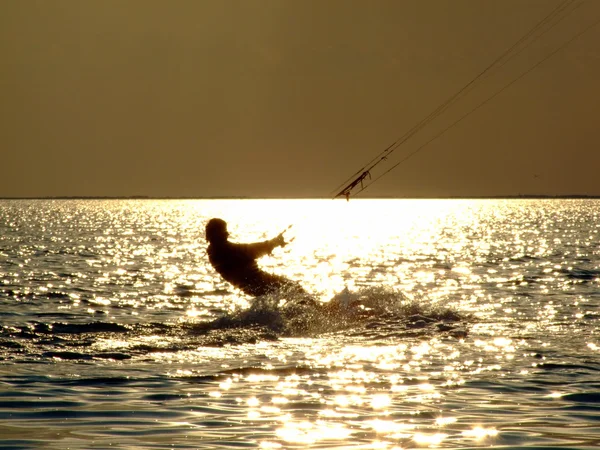 Silhuetas kitesurf em um golfo em uns sóis — Fotografia de Stock