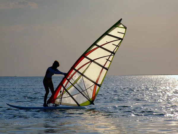Uma mulher está aprendendo windsurf no s — Fotografia de Stock
