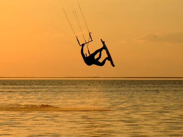 Silueta de un kitesurf, un vuelo por encima — Foto de Stock