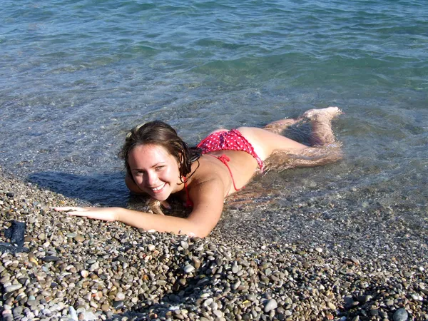 Das Sexmädchen liegt auf einem Kieselstein auf dem Meer — Stockfoto