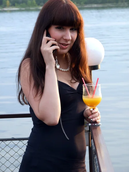 Девушка с коктейлем разговаривает с Мобилем — стоковое фото