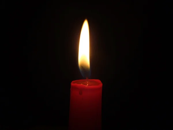 stock image The red candle burning in full darkness