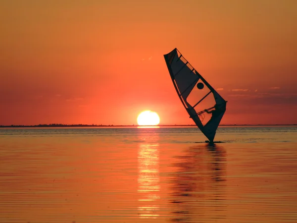 Silhueta de um windsurfista em ondas de um — Fotografia de Stock