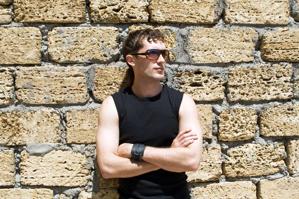 Young man in sunglasses standing near a — Stock Photo, Image