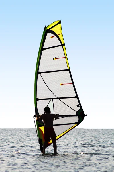 Silueta de un windsurfista en olas de un — Foto de Stock