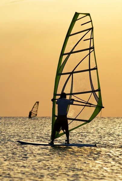 Siluetas de un windsurfista en olas de — Foto de Stock