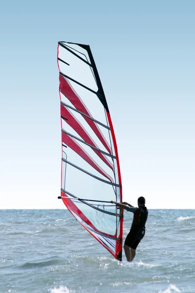 Silhouette of a windsurfer on waves of a — Stock Photo, Image