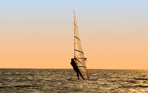 Silhouette di un windsurfer su onde di un — Foto Stock