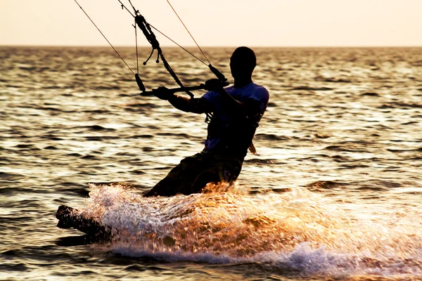 Silueta de un kitesurfista sobre una ola —  Fotos de Stock