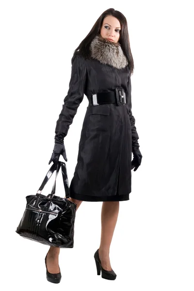 Die junge Frau im schwarzen Mantel mit einem b — Stockfoto