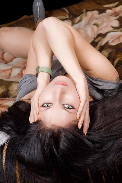 Krásná mladá brunetka leží na b — Stock fotografie