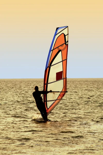 Silueta de un windsurfista en olas de un — Foto de Stock