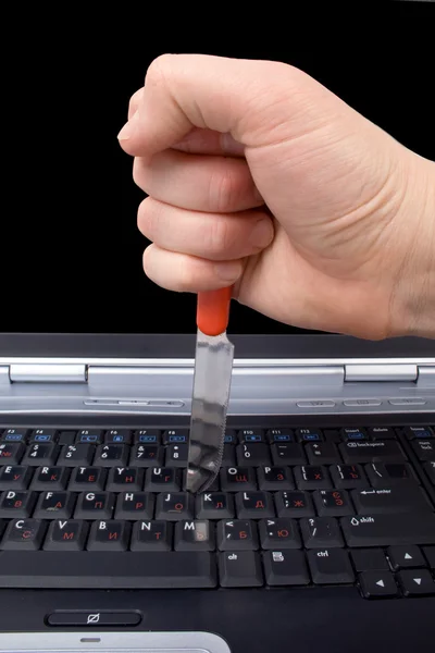 Mão com uma faca no teclado do laptop — Fotografia de Stock