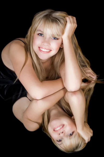 De jonge blonde en haar weerspiegelen glimlachen — Stockfoto