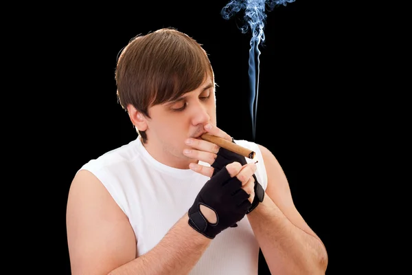 Young man sets fire to a cigar — Stock Photo, Image