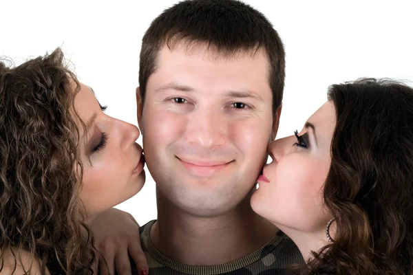 Two beautiful girls kiss the young man — Stock Photo, Image