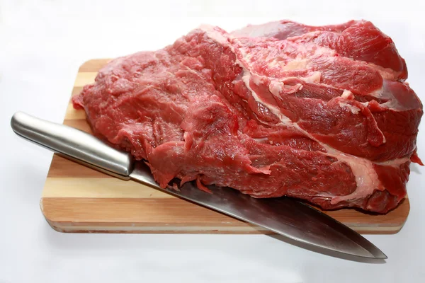 Carne con un coltello su un tagliere — Foto Stock