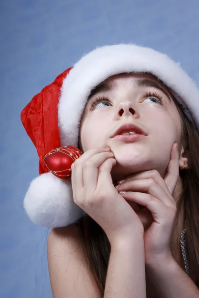 Mädchen steckt in der Weihnachtsmütze. — Stockfoto