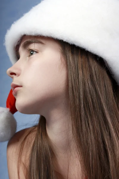 Mädchen steckt in der Weihnachtsmütze. — Stockfoto