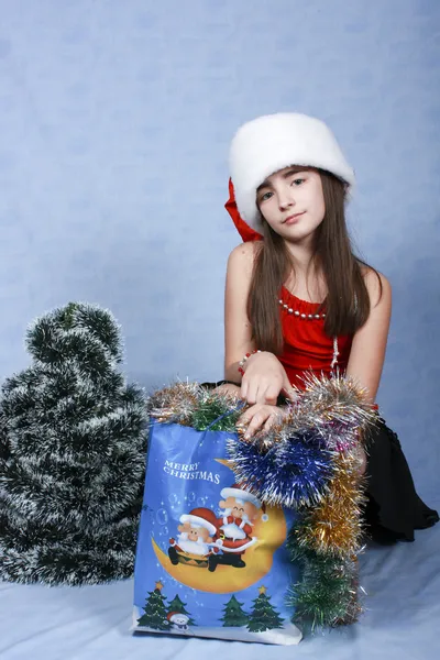 Girl with purchases in the Christmas cap — Stock Photo, Image