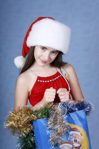 Girl with purchases in the Christmas cap — Stock Photo, Image