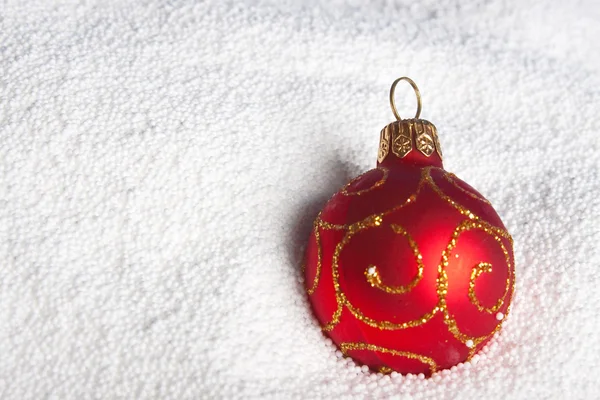 Red Christmas bauble on to snow. — Stock Photo, Image