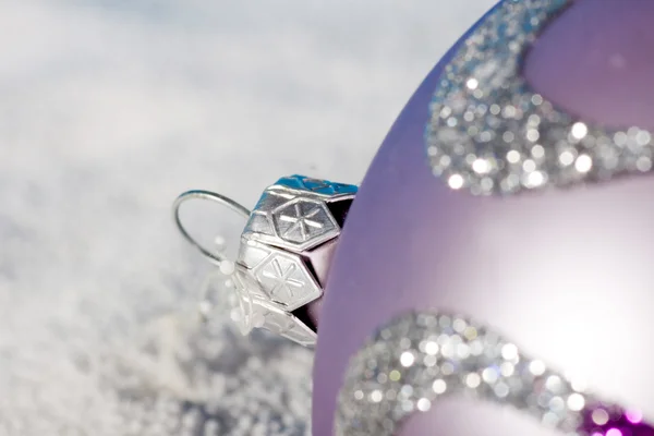 Tender lilac Christmas bauble on to snow — Stock Photo, Image