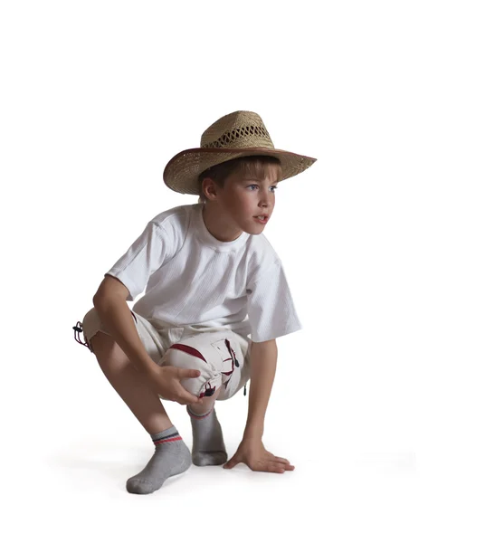 Sedí kluk slaměný klobouk na bílém poza — Stock fotografie