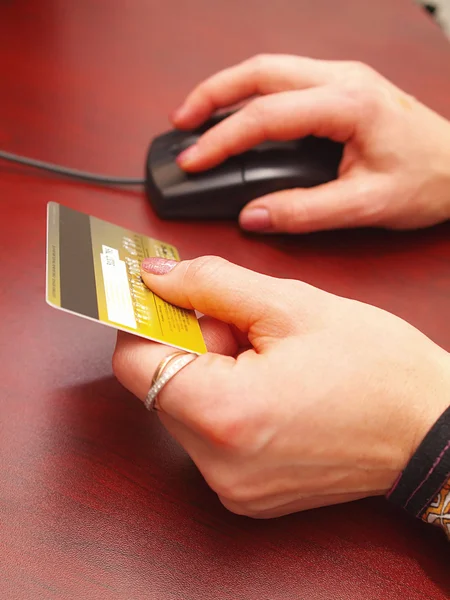 Vrouwelijke handen houden een credit card en de — Stockfoto