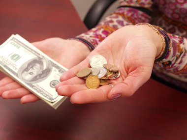 Female hands weigh coins and denominatio clipart