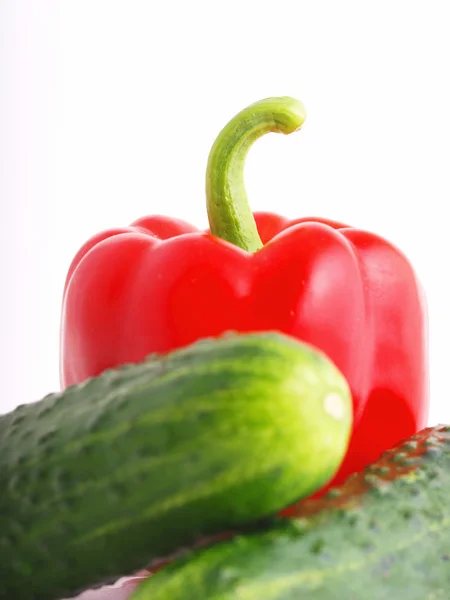 Rød peber og to agurker på en whit - Stock-foto