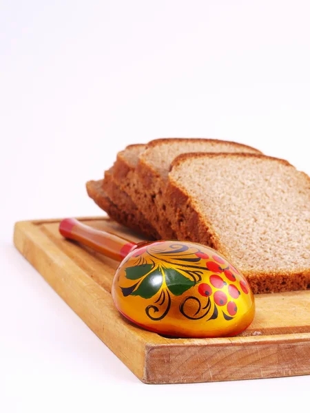 Brot, Löffel und Brett auf weißem — Stockfoto