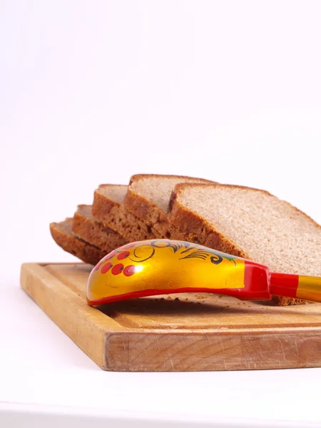 Pão, colher e tábua sobre um branco — Fotografia de Stock
