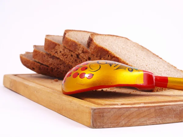 Pão, colher e tábua sobre um branco — Fotografia de Stock