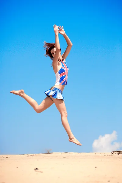 Menina pulando em um fundo de céu azul — Fotografia de Stock