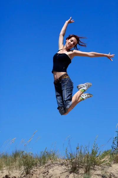 Dziewczyna skoki na tle niebieskiego nieba — Zdjęcie stockowe