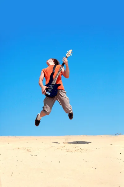 Młody człowiek z gitara skoki — Zdjęcie stockowe