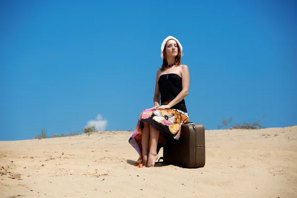 美丽的女孩走在沙子与 suitc — 图库照片