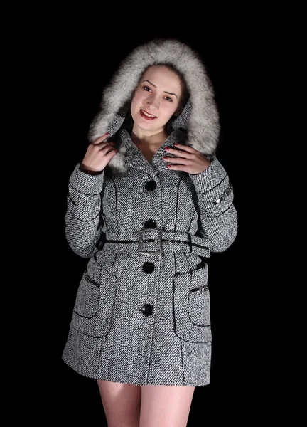 Kvinna i grå kappa på svart bakgrund — Stockfoto