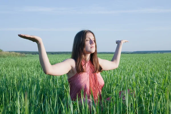 緑の牧草地でヨガをやっている若い女性 — ストック写真