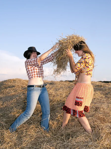 Happy girls play with hay — Stock Photo, Image
