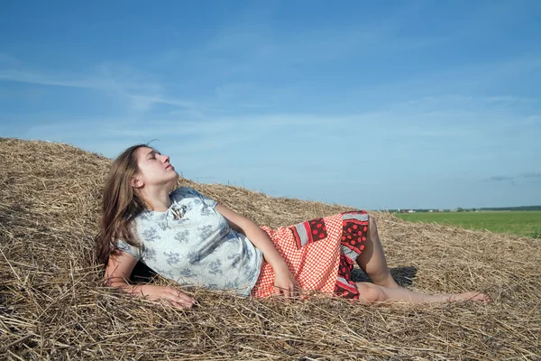Girl laying in hay — Stock Photo, Image